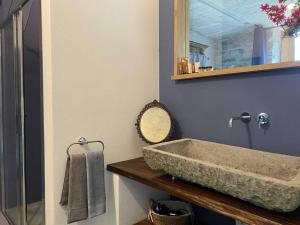 La salle de bains est pourvue d'un lavabo en pierre et d'un miroir. dans l'établissement Casa 1000fiori, à Faggeto Lario 