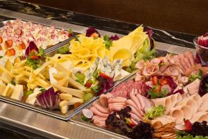 a buffet of different types of cheese and meats at Aparthotel Basztowa in Krakow