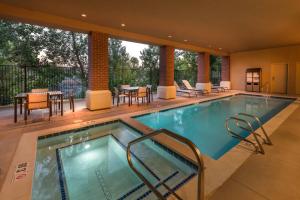 a swimming pool in a hotel with tables and chairs at Courtyard by Marriott Reno Downtown/Riverfront in Reno