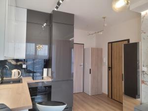 a kitchen with gray cabinets and a sink at Apartament Centrum Pestige Mińsk in Mińsk Mazowiecki