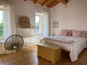a bedroom with a bed and a chair and a window at B&B Casa Trambasore in Caprino Veronese