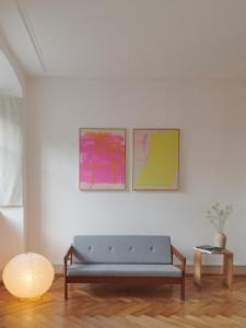 ein Wohnzimmer mit einem blauen Sofa und zwei Gemälden in der Unterkunft Auberge du Mouton in Pruntrut