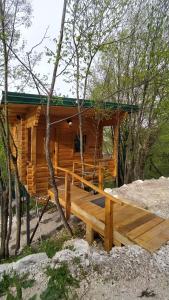 eine Blockhütte im Wald mit einer großen Terrasse in der Unterkunft Still cabin in Cetinje