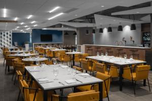 a dining room with tables and yellow chairs at Courtyard by Marriott Calgary Downtown in Calgary