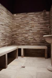 a bench in a room with a brick wall at Principe Alogna Hotel & SPA in Altavilla Milicia