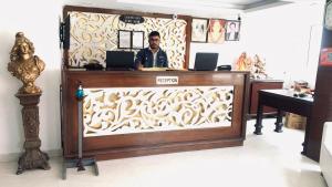a man is sitting at a counter in a room at Hotel Royal Classic @ Mall Road Mussoorie in Mussoorie