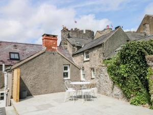 een patio met een tafel en stoelen voor een gebouw bij 10 Westgate Hill in Pembroke