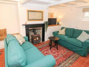 a living room with two blue couches and a fireplace at 10 Westgate Hill in Pembroke