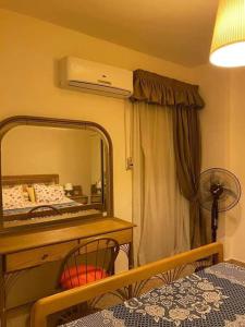 a bedroom with a mirror and a table with a bed at Chalet in Stella Marina, El Alamein in El Alamein