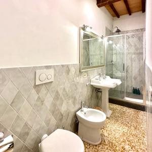 y baño con aseo y lavamanos. en Dimora del Poggio a San Quirico d’Orcia, en San Quirico dʼOrcia
