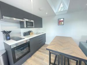 a kitchen with a sink and a table in it at Martindale & Fusedale Lodge in Penrith