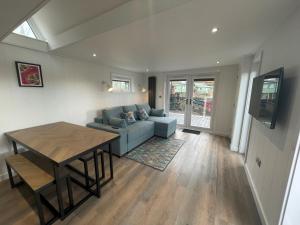 a living room with a blue couch and a table at Martindale & Fusedale Lodge in Penrith