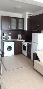 a kitchen with brown cabinets and a white appliance at ЖК Sunshine&lov Апартамент Релакс in Kranevo