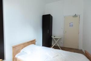 - une chambre avec un lit, une porte et une table dans l'établissement Hôtel Le Paris Brest, à Lens