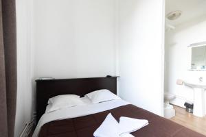 - une chambre avec un lit et des oreillers blancs dans l'établissement Hôtel Le Paris Brest, à Lens