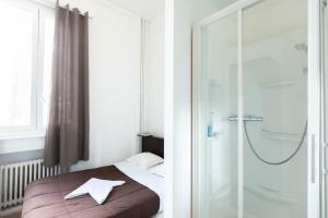 sypialnia z łóżkiem i przeszklonym prysznicem w obiekcie Hôtel Le Paris Brest w mieście Lens