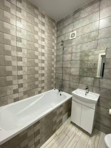 a bathroom with a tub and a toilet and a sink at GIL Apartments, Volodimirskaja 90.212 - Majetok Bozdosh in Uzhhorod