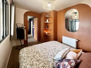 - une chambre avec un lit et un miroir dans l'établissement L'Arc-en-Ciel Scandinave - Séjour unique et design au cœur de Rouen, à Rouen
