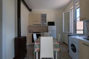 a kitchen with a table and a kitchen with a refrigerator at La Casetta di Filomena in Lama Di Peligni