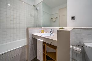 a bathroom with a sink and a tub and a toilet at Habitat Apartments Barcelona Balconies in Barcelona