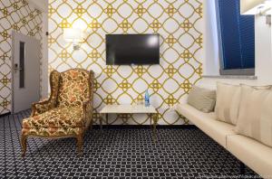 a living room with a couch and a tv at Amber Suite Szczecin hotel na Starym Mieście Adults Only in Szczecin