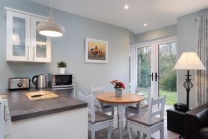 uma cozinha e sala de jantar com mesa e cadeiras em Cottage 420 - Clifden em Clifden
