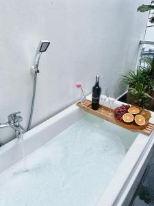 MIHA Villa & Stay في Cái Răng: حوض استحمام مليء بالمياه الغازية مع كؤوس النبيذ