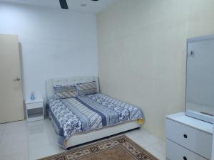 una camera da letto con un letto in una stanza bianca di Escape Homestay a Sungai Petani