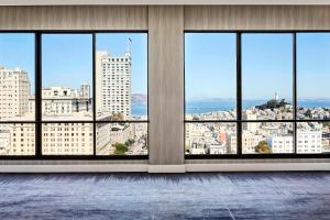 an empty room with views of a city from windows at San Francisco Marriott Union Square in San Francisco