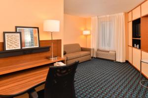 een hotelkamer met een tafel en een bank bij Fairfield Inn & Suites Cleveland Avon in Avon