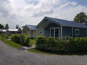 a row of houses on a gravel road at De Bijsselse Enk, Noors chalet 15 in Nunspeet