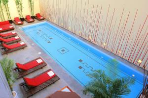 una vista aérea de una piscina con sillas rojas en Mexico City Marriott Reforma Hotel, en Ciudad de México