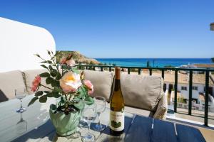 - une table avec une bouteille de vin et des fleurs dans l'établissement Ramalhete panoramic view apartment, à Luz