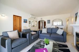 - un salon avec deux canapés bleus et une table dans l'établissement Ramalhete panoramic view apartment, à Luz