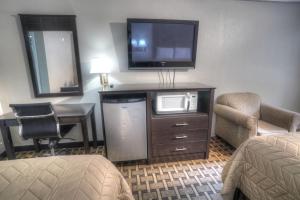 um quarto de hotel com televisão, secretária e cadeira em Amerivu Inn & Suites - Helen - Downtown em Helen