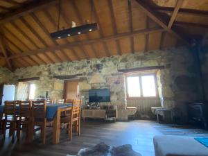 a dining room with a table and chairs in a stone building at Quinta do Mirante in Celorico de Basto