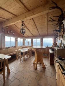 - une cuisine avec des plafonds en bois, des tables et des chaises dans l'établissement Almhütte Möschbauer Nähe Redbull Ring, à Rottenmann