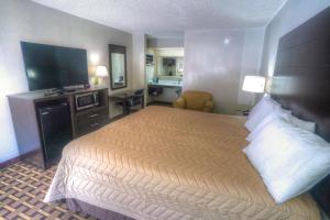 a hotel room with a bed and a flat screen tv at Amerivu Inn & Suites - Helen - Downtown in Helen