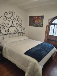 Un dormitorio con una cama con una manta azul. en Casa valicha, en Cusco