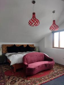 庫斯科的住宿－Casa valicha，一间卧室配有一张床和一张粉红色的沙发