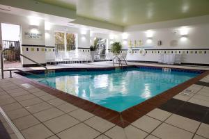 une grande piscine dans le hall de l'hôtel dans l'établissement Fairfield Inn and Suites Flint Fenton, à Fenton