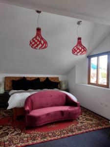 a bedroom with a pink couch in front of a bed at Casa valicha in Cusco