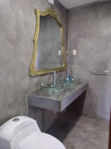 y baño con lavabo con espejo y aseo. en Casa valicha, en Cusco