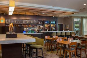 a restaurant with tables and chairs and a bar at Courtyard by Marriott Nashville Goodlettsville in Goodlettsville