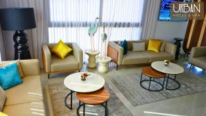 uma sala de estar com duas mesas e dois sofás em Urban Hotel & Spa em Kenitra