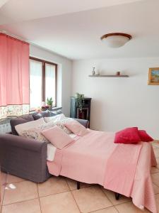 - une chambre avec un grand lit et un canapé dans l'établissement Casa Pepolina, zona tranquilla, piano terra con parcheggio, à Malesco