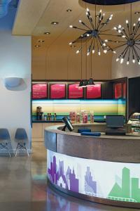 a fast food restaurant with a counter with chairs at Aloft Harlem in New York