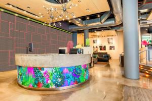 a lobby with a counter with a colorful wall at Aloft Harlem in New York