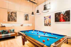 a room with a pool table and some paintings at Aloft Harlem in New York