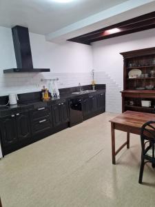 a kitchen with black cabinets and a wooden table at Casa Phitaya in Playa Honda